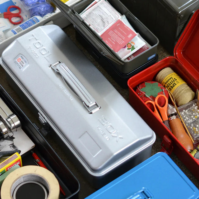 Collection of various tools and supplies including a gray toolbox, red toolbox with sewing materials, and blue toolbox.