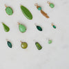 Collection of green jewelry pieces on a light gray background