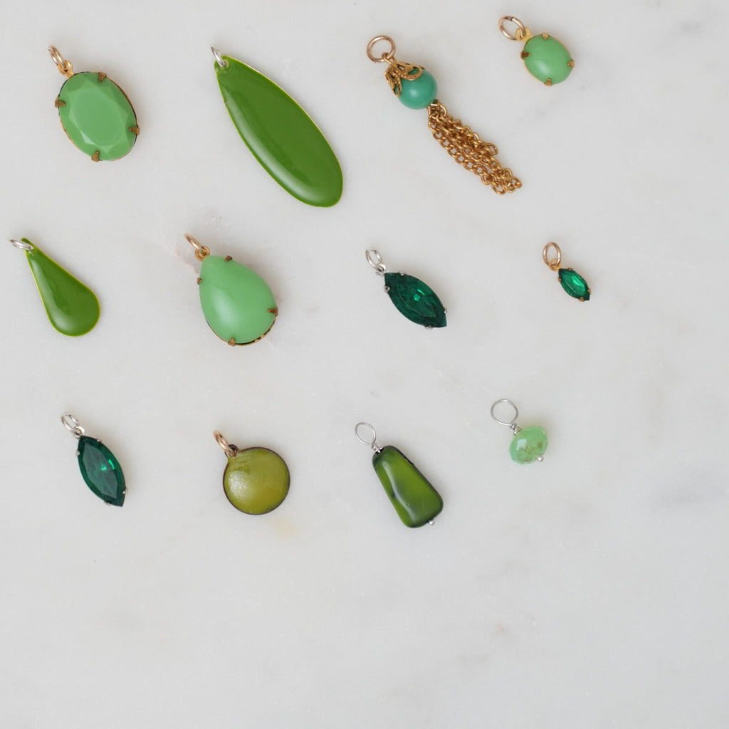 Collection of green jewelry pieces on a light gray background
