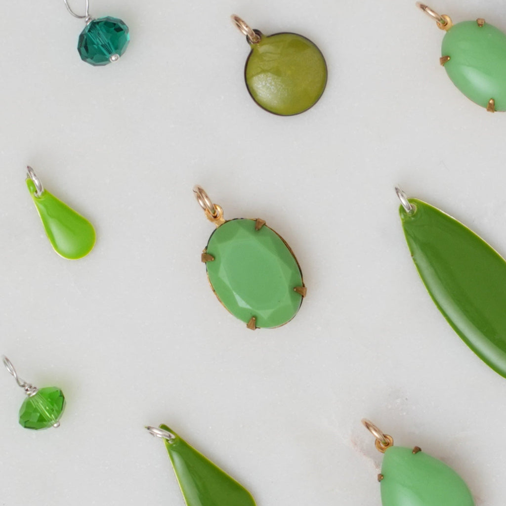 Green jewelry pendants on a light background