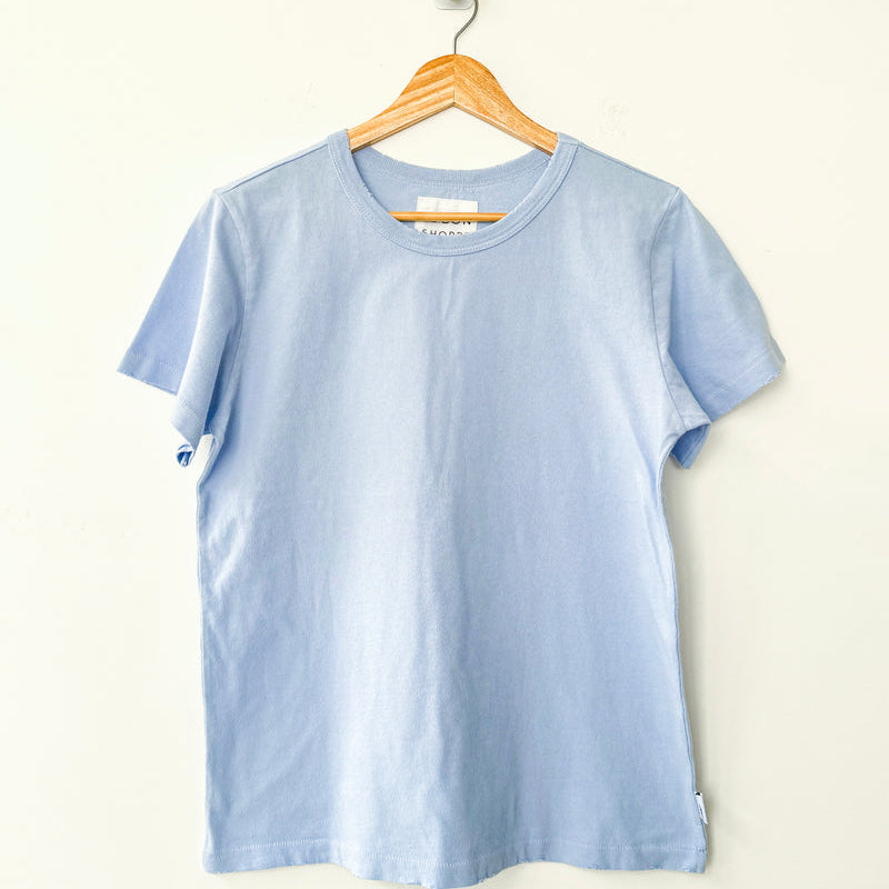 Light blue t-shirt by Le Bon Shoppe on a wooden hanger against a white background