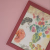 Framed artwork with floral and bird design on a pink background