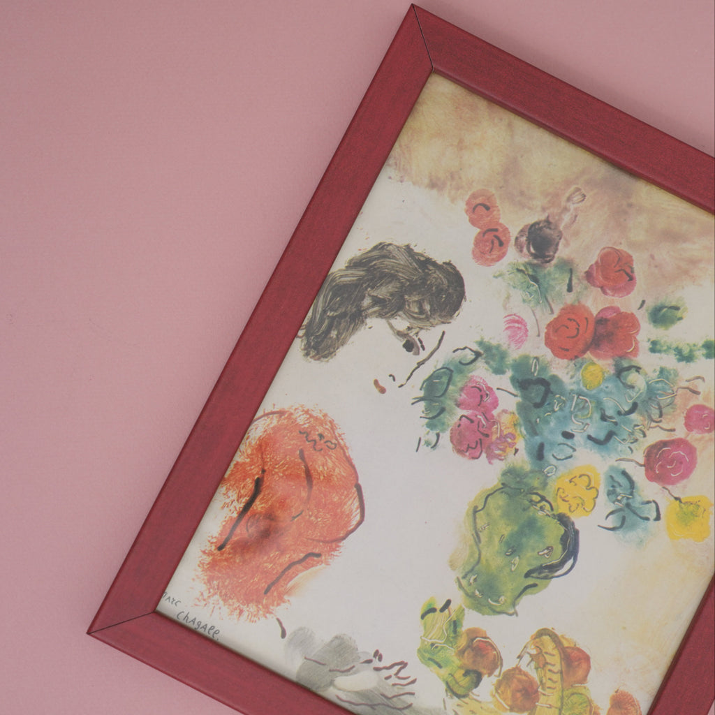 Framed artwork with floral and bird design on a pink background