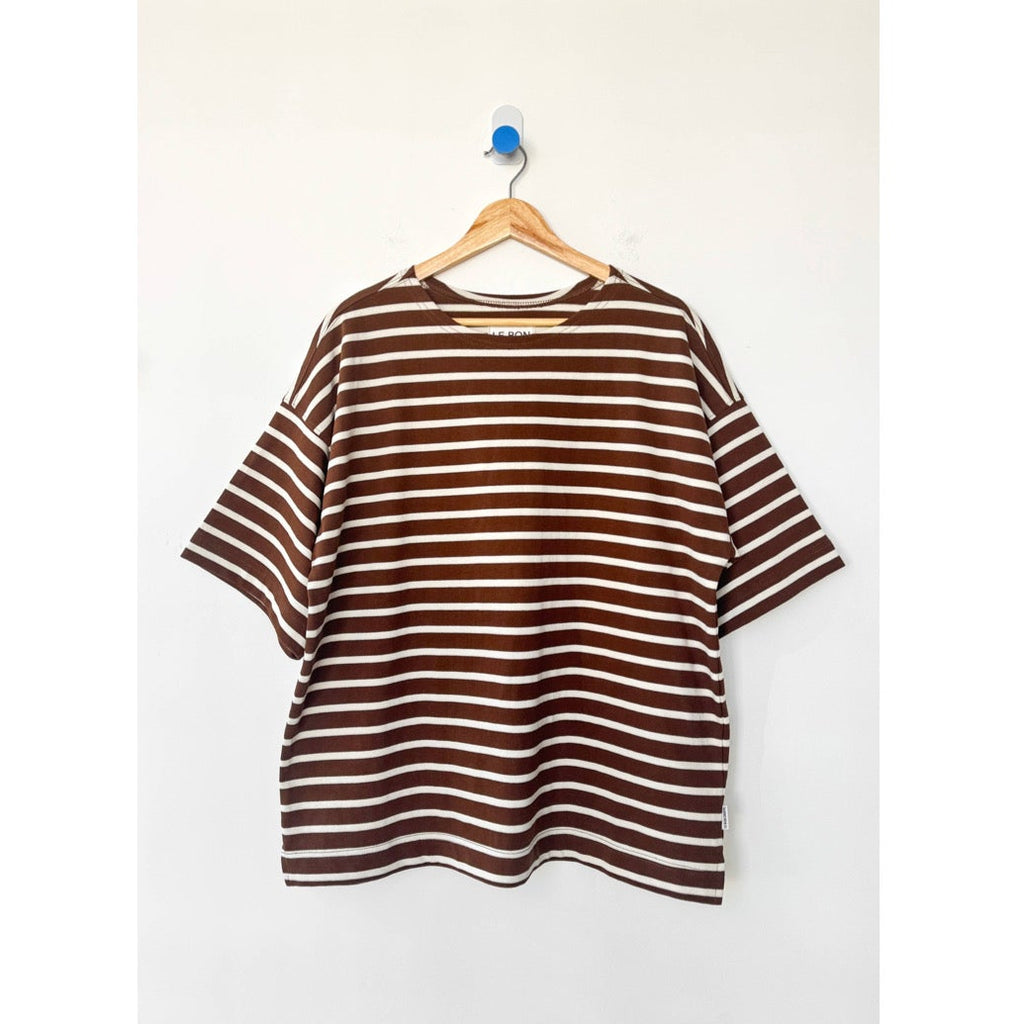 Brown and white striped voyage shirt on a hanger against a white background