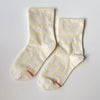 Pair of white socks with yellow stripes on a light gray background
