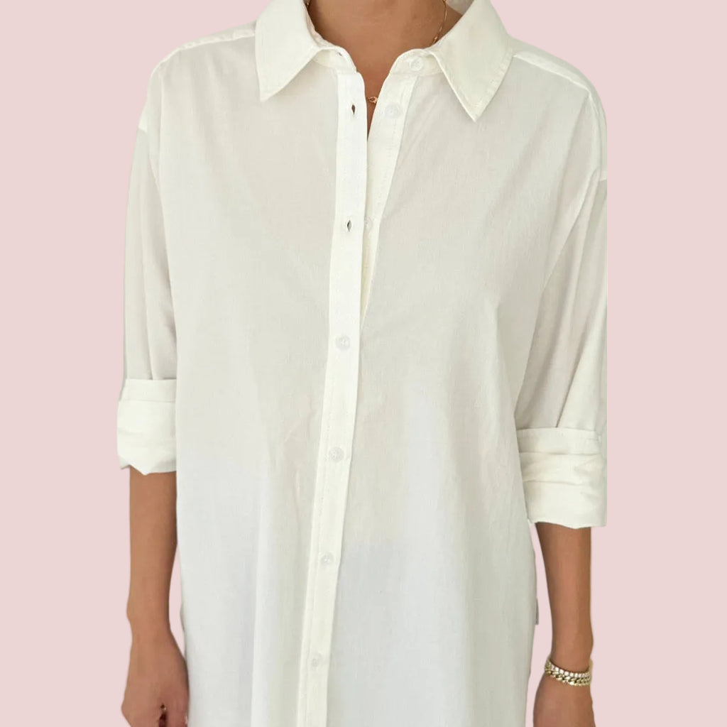 White button-up shirt worn by a person on a pink background