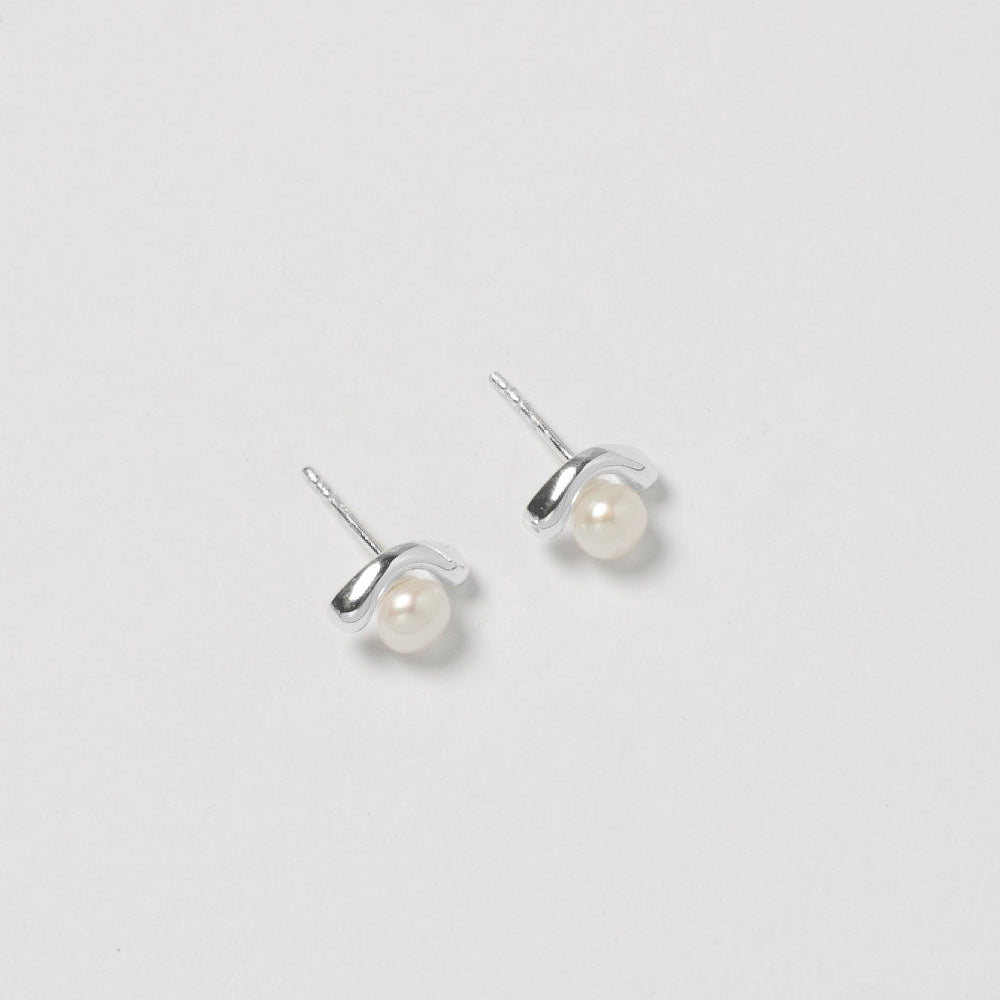 Pair of pearl stud earrings on a light gray background