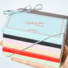 Hand holding a colorful box with 'Superfine New York' branding on a light background