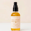 Bottle of High Noon Body Oil with a beige background