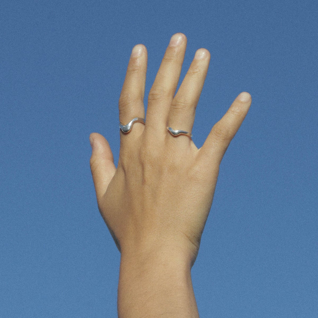 Hand with sterling silver organic shaped wave band ring