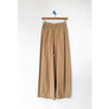 Beige wide-leg pants hanging on a white background
