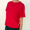 Person wearing a red noel t-shirt on a plain background