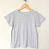 Gray t-shirt on a wooden hanger against a beige background
