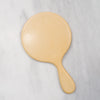 Vintage butter yellow handheld beveled celluloid circle mirror.