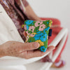 Flowerbed Pink and Green Floral Puffy Earbuds Case by Baggu at Golden Rule Gallery in Excelsior, MN