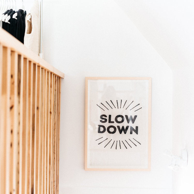 Slow Down Tea Towel Framed And Hanging On White Wall | Framed Textiles Print | Golden Rule Gallery | Sir Madam | Excelsior, MN