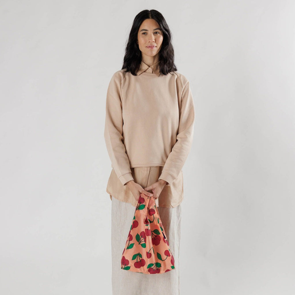 Model Holding Small Cherry Print Reusable Bag Baggu at Golden Rule Gallery