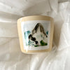 A MANO View Cup with Mountain Landscape Watercolor Painted on it against White Fabric