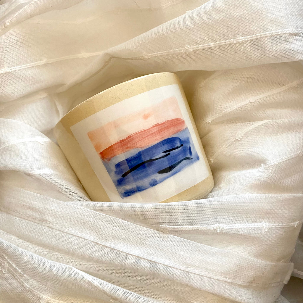 Pretty A MANO Hand Made MPLS Painted Ceramic Cup Against White Fabric Background