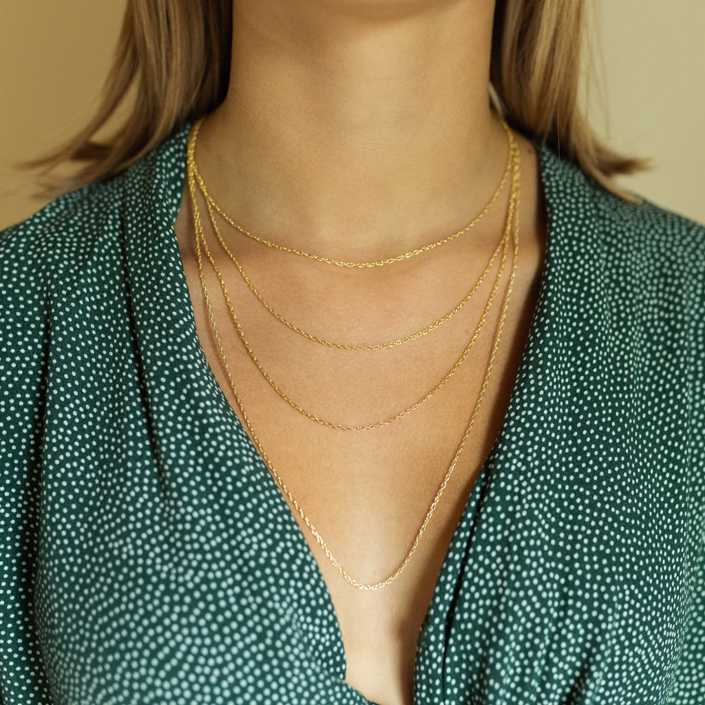 Layered gold necklaces on model