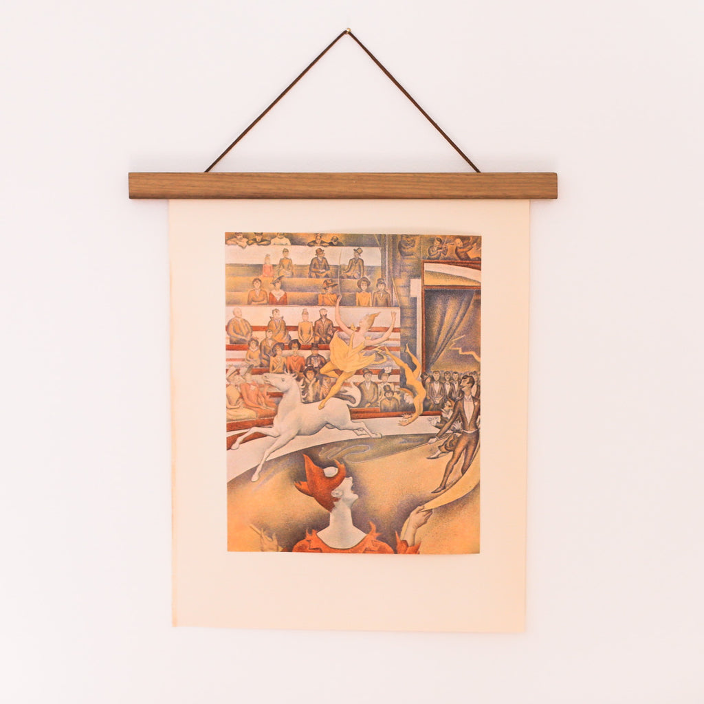 Vintage 50s Seurat Offset Lithograph of The Circus, hanging on a teakwood poster wall hanger